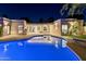Stunning backyard at dusk featuring a pool, outdoor living space, and architectural lighting at 7278 E Echo Ln, Scottsdale, AZ 85258