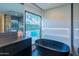 Elegant bathroom with a standalone tub overlooking the pool area at 7278 E Echo Ln, Scottsdale, AZ 85258