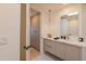 Contemporary bathroom with a light wood vanity, modern lighting, and access to a spacious walk-in closet at 7278 E Echo Ln, Scottsdale, AZ 85258