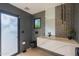 Modern bathroom features a textured accent wall, floating vanity, and sleek black fixtures for a contemporary feel at 7278 E Echo Ln, Scottsdale, AZ 85258