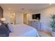 Bright bedroom with a large bed, modern dresser, and a view of an ensuite bathroom with a glass shower at 7278 E Echo Ln, Scottsdale, AZ 85258