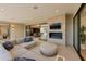 Inviting outdoor living area with a plush sectional sofa, outdoor fireplace, and seamless indoor-outdoor transition at 7278 E Echo Ln, Scottsdale, AZ 85258