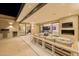 Luxurious covered patio with fireplace, outdoor seating, and grill area, merging indoor and outdoor living spaces at 7278 E Echo Ln, Scottsdale, AZ 85258