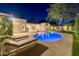 A luxurious backyard pool with outdoor kitchen, lounge seating, and manicured landscaping with nighttime lighting at 7278 E Echo Ln, Scottsdale, AZ 85258