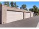View of a row of attached garages with neutral-colored doors and textured exterior walls, offering ample parking and storage at 7312 N Via Camello Del Norte St # 95, Scottsdale, AZ 85258
