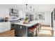 Spacious kitchen featuring a large island with seating, white cabinetry, stainless steel appliances, and wood floors at 8001 N 3Rd Pl, Phoenix, AZ 85020