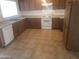 Functional kitchen with white appliances, wood cabinets and ample counter space at 8141 W Elm St, Phoenix, AZ 85033