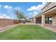Well-maintained backyard featuring artificial grass, a cozy firepit, and a covered patio area at 9743 E Torino Ave, Mesa, AZ 85212