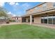 Backyard features artificial grass, covered patio, brick pavers and desert landscaping at 9743 E Torino Ave, Mesa, AZ 85212