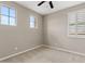 Neutral bedroom with ceiling fan, two large windows, and neutral carpet at 9743 E Torino Ave, Mesa, AZ 85212