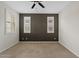Bedroom with dark accent wall, neutral carpet, two windows, and ceiling fan at 9743 E Torino Ave, Mesa, AZ 85212