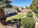 Well-maintained backyard with green lawn, mature trees, and privacy hedges, ideal for outdoor enjoyment at 10928 W Kaler Dr, Glendale, AZ 85307