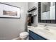 This stylish bathroom showcases gray walls, a blue vanity, decorative mirror, and modern shelves for optimal organization at 1225 N 36Th St # 2101, Phoenix, AZ 85008