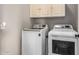 Efficient laundry room equipped with a modern washer and dryer, complemented by overhead cabinetry for storage solutions at 1225 N 36Th St # 2101, Phoenix, AZ 85008