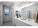 Bathroom with double sinks, white cabinetry, and modern fixtures, creating a bright and clean space at 13195 N 145Th Ln, Surprise, AZ 85379