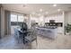 Elegant dining area with modern chandelier, stylish seating, and seamless flow to the kitchen and outdoor patio at 13195 N 145Th Ln, Surprise, AZ 85379