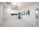 Sunlit room featuring neutral walls, a modern chandelier, and a glimpse of the neighborhood through the window at 13195 N 145Th Ln, Surprise, AZ 85379