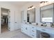 Bathroom with double vanity, mirrors, makeup table, and entry to a walk-in closet at 13929 E Barwick Dr, Scottsdale, AZ 85262