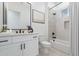 Bright bathroom featuring a vanity with white cabinets, a modern mirror, and a shower-tub combo at 13929 E Barwick Dr, Scottsdale, AZ 85262