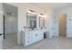 Bathroom with double vanity, mirrors, makeup table, and entry to a walk-in closet at 13929 E Barwick Dr, Scottsdale, AZ 85262