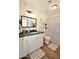 Stylish bathroom featuring wood flooring, white cabinets, and modern black and white polka dot shower curtain at 1450 N Sailors Way, Gilbert, AZ 85234