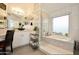 Bright bathroom featuring dual sinks, a large soaking tub, and glass block accents at 1450 N Sailors Way, Gilbert, AZ 85234