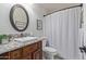 Bathroom featuring vanity with granite countertop, vessel sink and oval mirror, plus shower with curtain at 15816 W Amelia Dr, Goodyear, AZ 85395