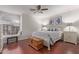 Bright bedroom with wood floors, ceiling fan, window seat, and coastal artwork above the bed at 15816 W Amelia Dr, Goodyear, AZ 85395