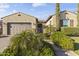 This home's exterior features a two-car garage and manicured bushes and plants at 16026 W Cortez St, Surprise, AZ 85379