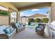 Covered outdoor living space with wicker furniture, a TV, and a view of the pool at 16026 W Cortez St, Surprise, AZ 85379