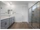 Modern bathroom featuring a dual vanity, stylish mirrors, a glass-enclosed shower, and tile floors at 17307 W Via Dona Rd, Surprise, AZ 85387