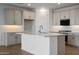This modern kitchen features white cabinets, black stainless appliances, and sleek countertops with backsplash at 17307 W Via Dona Rd, Surprise, AZ 85387