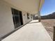 Covered back patio with concrete flooring, adjacent to a yard and sliding glass doors to the home at 17547 W Lupine Ave, Goodyear, AZ 85338