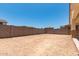 Expansive backyard enclosed by a tall block fence, offering privacy and potential for landscaping at 17547 W Lupine Ave, Goodyear, AZ 85338