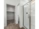A modern bathroom with a glass enclosed shower and a door leading to a closet at 17547 W Lupine Ave, Goodyear, AZ 85338