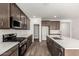 Bright, modern kitchen with stainless steel appliances, white countertops, and dark wood cabinets at 17547 W Lupine Ave, Goodyear, AZ 85338