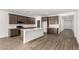 Spacious kitchen featuring wooden floors, dark wood cabinets, white countertops, and stainless steel appliances at 17547 W Lupine Ave, Goodyear, AZ 85338