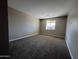 Spacious carpeted bedroom featuring a window providing natural light and modern paint at 17553 W Lupine Ave, Goodyear, AZ 85338