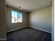 Cozy bedroom with plush carpet and a large window offering neighborhood views at 17553 W Lupine Ave, Goodyear, AZ 85338