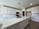 Bright kitchen showcasing a center island, white cabinetry and subway tile backsplash at 17553 W Lupine Ave, Goodyear, AZ 85338