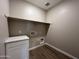 Dedicated laundry room with upper shelving and room for washer and dryer at 17553 W Lupine Ave, Goodyear, AZ 85338