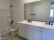 Bathroom featuring a double sink vanity with black hardware and a tub and shower combo with black fixtures at 18035 W Vogel Ave, Goodyear, AZ 85338