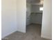 Spacious walk-in closet with open shelving and neutral carpet, offering ample storage solutions at 18035 W Vogel Ave, Goodyear, AZ 85338