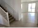 Bright entryway with staircase, leading into an open living area with tiled floors at 18035 W Vogel Ave, Goodyear, AZ 85338