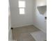 Bright laundry room features a window, utility sink, storage shelf and tile floors at 18035 W Vogel Ave, Goodyear, AZ 85338