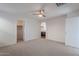 Spacious bedroom featuring a ceiling fan, neutral carpet, and access to a walk-in closet and bathroom at 1940 N 78Th Gln, Phoenix, AZ 85035