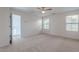 Bright and spacious bedroom featuring neutral carpet, two windows, and easy access to a walk-in closet at 1940 N 78Th Gln, Phoenix, AZ 85035