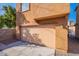 Exterior view of attached one car garage in neutral color with large cement driveway and a brick wall at 1940 N 78Th Gln, Phoenix, AZ 85035