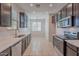 Modern kitchen with dark cabinets, stainless steel appliances, marble countertops, and recessed lighting at 1940 N 78Th Gln, Phoenix, AZ 85035