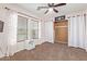 Cozy bedroom features a ceiling fan, two windows, and a closet with white curtains at 21784 E Puesta Del Sol --, Queen Creek, AZ 85142